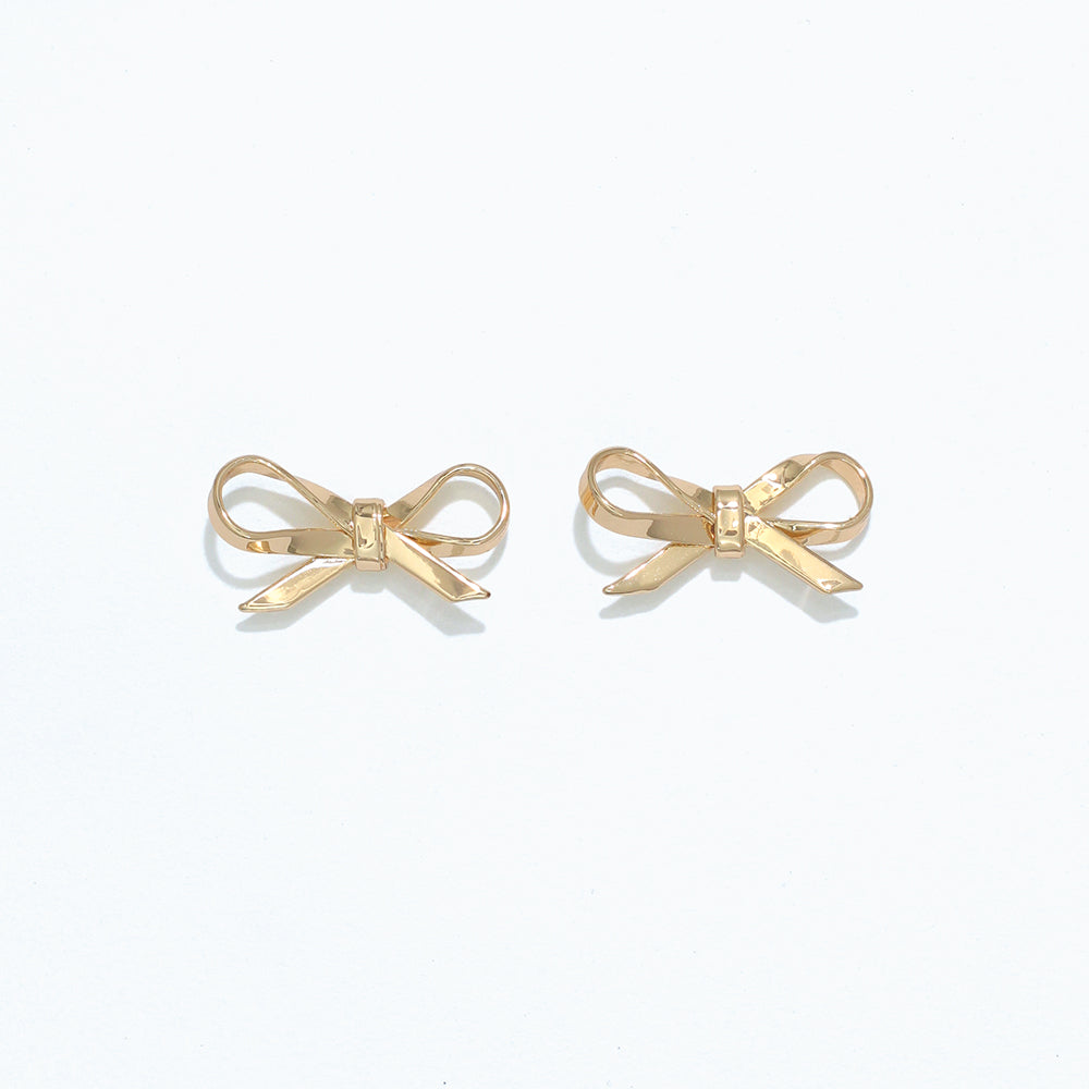 A pair of silver ribbon bow stud earrings on a white background. Available at Be Charmed