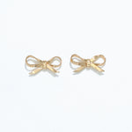 A pair of silver ribbon bow stud earrings on a white background. Available at Be Charmed