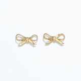 A pair of silver ribbon bow stud earrings on a white background. Available at Be Charmed