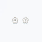 A pair of pearlized flower design hypoallergenic stainless steel post earrings. Available at Be Charmed