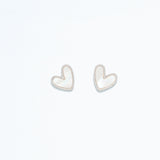 A pair of pearlized silver heart earrings on a white background. Available at Be Charmed