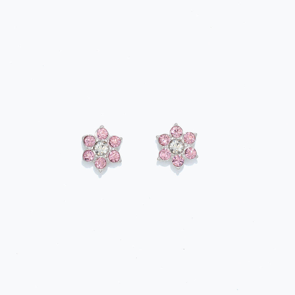 A pair of crystal flower earrings with pink petals and a central clear crystal, on a white background. Available at Be Charmed