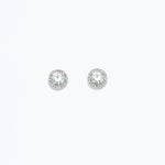 A pair of round crystal statement earrings in silver, featuring a bed of small clear crystals around a central larger crystal. Available at Be Charmed