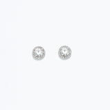 A pair of round crystal statement earrings in silver, featuring a bed of small clear crystals around a central larger crystal. Available at Be Charmed