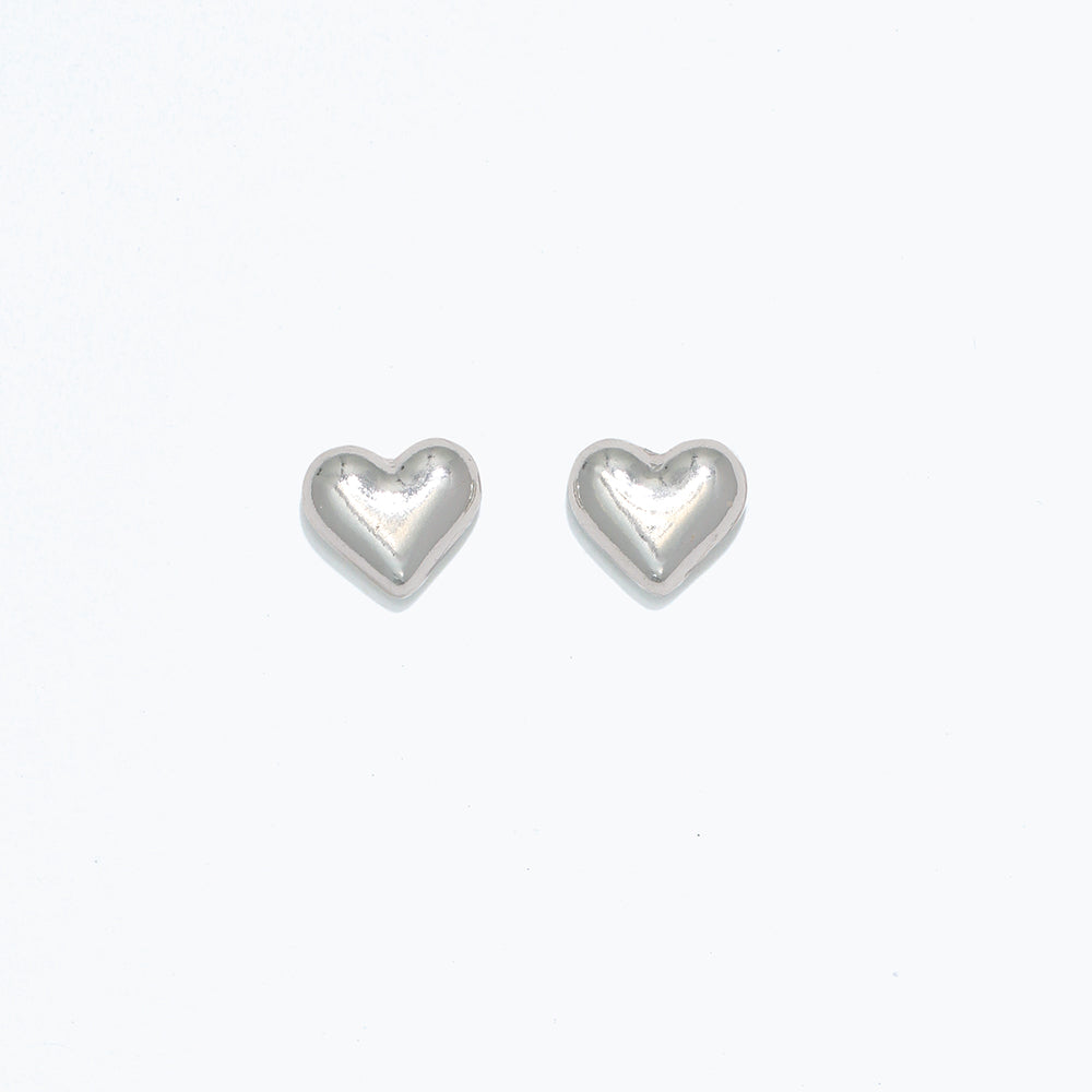 A pair of heart-shaped stud earrings on a white background, likely to be used as a playful accessory for personal jewelry. Available at Be Charmed