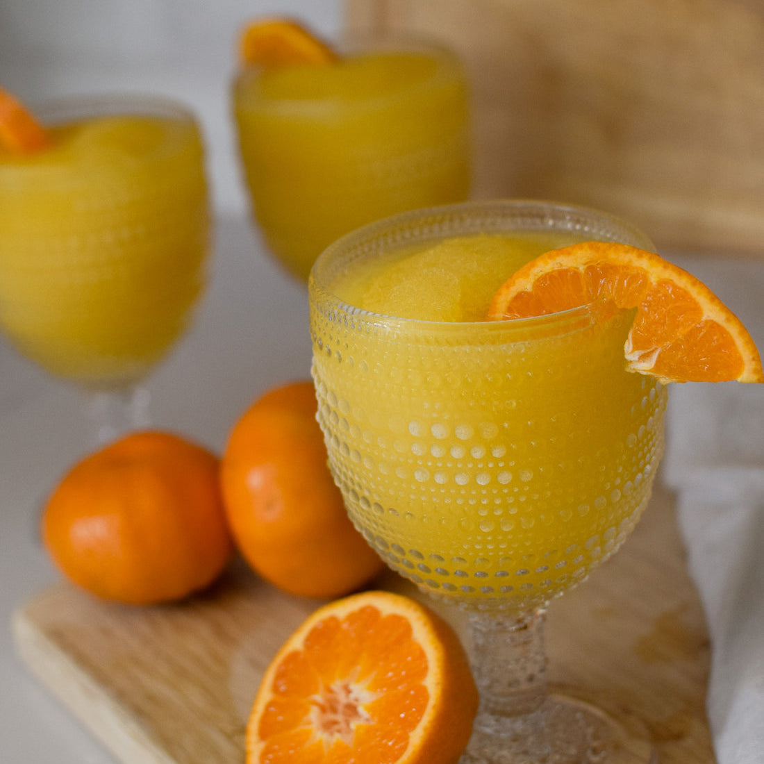 Picture of filled glass of D'marie Mimosa Slush Mix pouch with citrus design, a craft cocktail mix to combine with champagne and freeze. Refreshing and easy. Available at Be Charmed