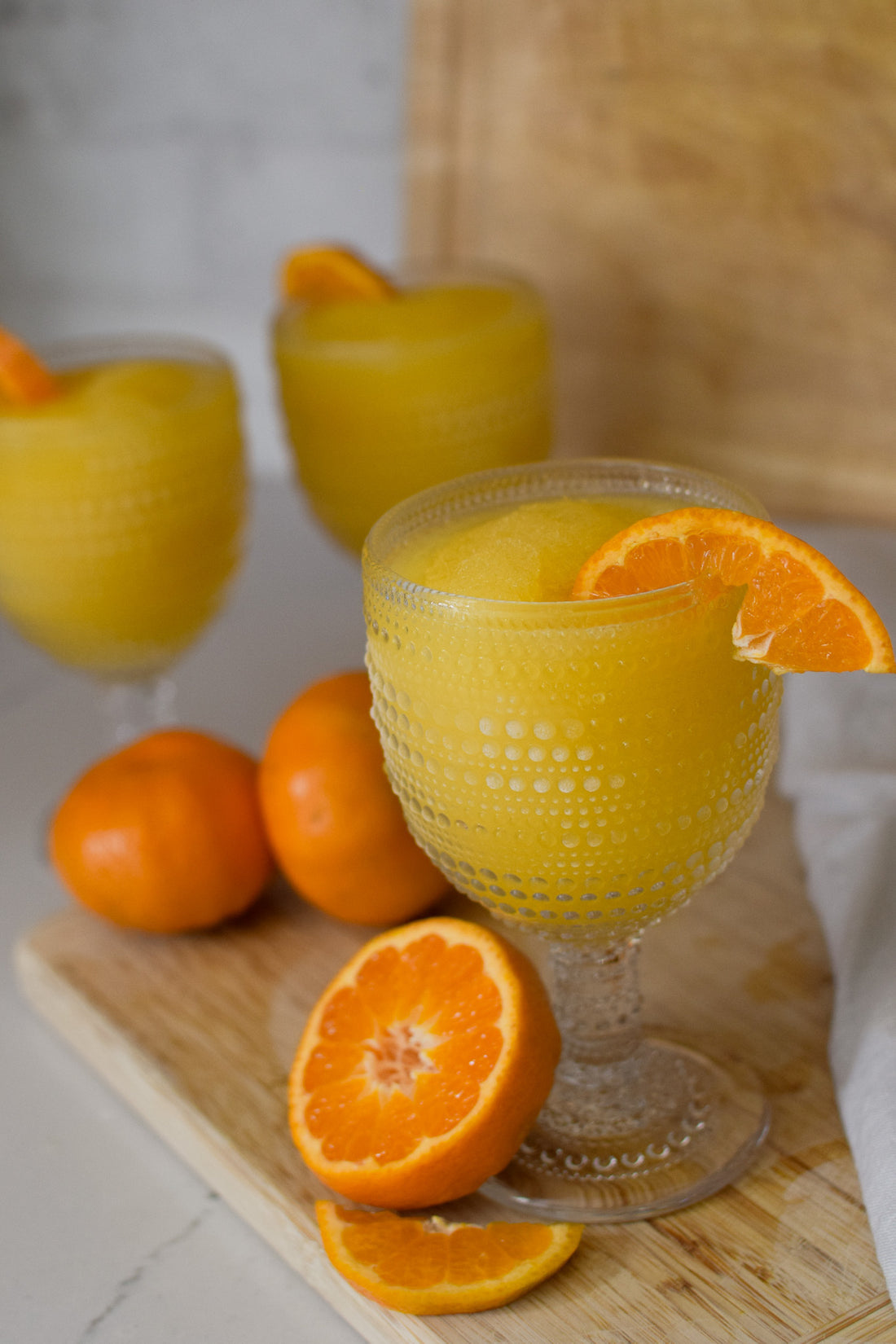 Picture of filled glass of D'marie Mimosa Slush Mix pouch with citrus design, a craft cocktail mix to combine with champagne and freeze. Refreshing and easy. Available at Be Charmed