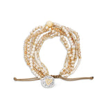 Multistrand champagne beaded bracelet with heart charm on a white background. Available at Be Charmed