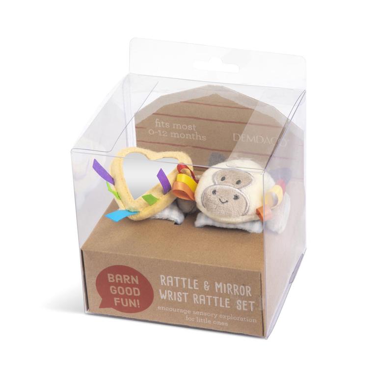 Pictured in box; Demdaco Cow Wrist Rattle, 6″ soft polyester baby toy with bright colors, secure hook-and-loop strap for sensory play and barnyard learning—available at Be Charmed.