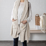 Demdaco Giving Shawl in cream (27″×70″), buttery‑soft fabric with two pockets—giftable hug, available at Be Charmed.
