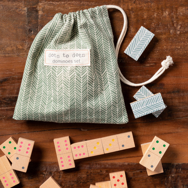 Demdaco Dots to Dots Domino Set, 28 wooden tiles with colored dots in green‑cream herringbone cotton drawstring bag—available at Be Charmed.