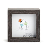 Demdaco “Friends Grow Together” shadow box – inspirational pebble art by Sharon Nowlan, 4″ square with glass frame. Available at Be Charmed
