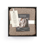 Demdaco Giving Shawl in box (27″×70″), buttery‑soft fabric with two pockets—giftable hug, available at Be Charmed.