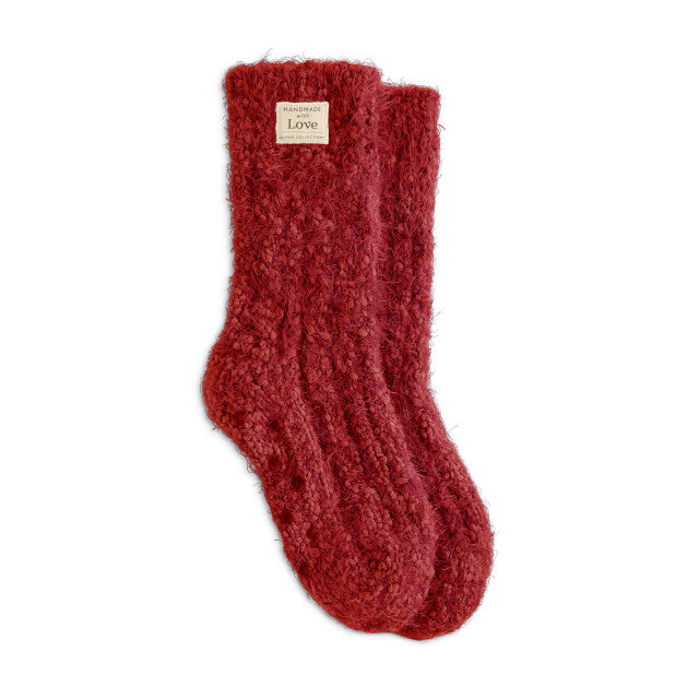 A pair of red Demdaco giving socks, made of plush fabric, displayed against a white background. Available at Be Charmed