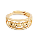 A gold colored ring with multiple small spherical embellishments around the band, designed to be adjustable by pinching at the back. Available at Be Charmed