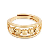 A gold colored ring with multiple small spherical embellishments around the band, designed to be adjustable by pinching at the back. Available at Be Charmed