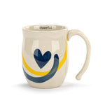Mug with blue heart design and yellow and blue stripes on a white background