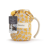 Floral-patterned drawstring bag with a mug inside on a white background. Available at Be Charmed