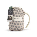 Drawstring bag with paw prints and a mug labeled 'dog mom' on a white background. Available at Be Charmed