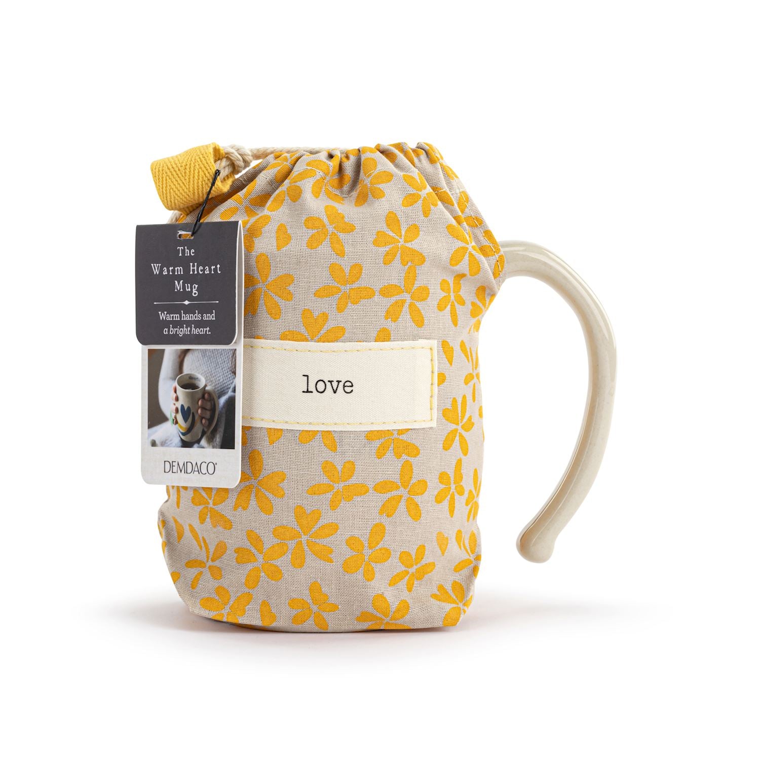 Mug with yellow floral pattern and 'love' tag, branded 'DEVAICO'. Available at Be Charmed