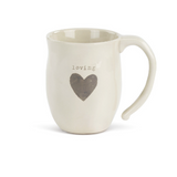 Cream‑white ceramic Dema­­co Heart Mug with red heart outline and “Loving” sentiment, 12 oz capacity—perfect for coffee, tea, or hot cocoa. Available at Be Charmed