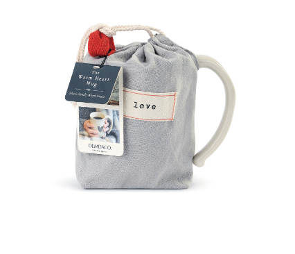Cream‑white ceramic Dema­­co Heart Mug in pouch with red heart outline and “Loving” sentiment, 12 oz capacity—perfect for coffee, tea, or hot cocoa. Available at Be Charmed