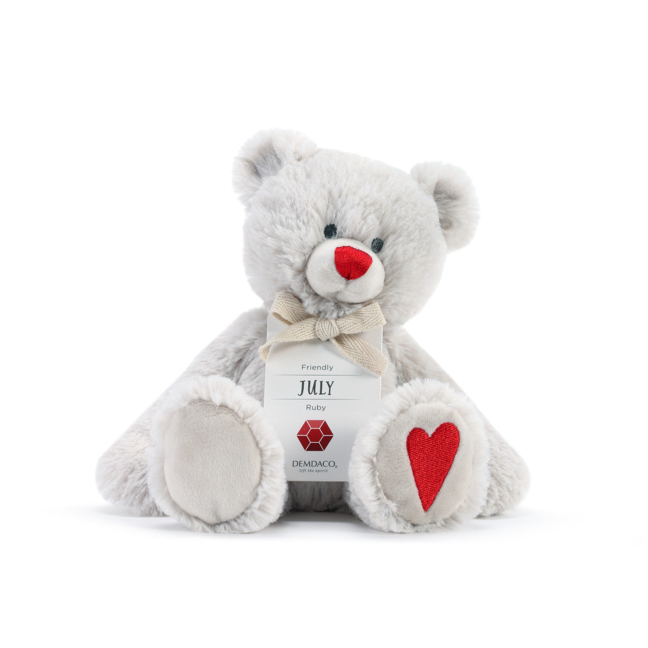 A plush teddy bear with a birthstone theme, featuring a ribbon around its neck that indicates the month of July. Available at Be Charmed