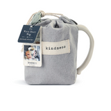 Demdaco “Kind” Heart Mug in pouch, 16 oz stoneware with heart cutout and “Kind” sentiment in warm ceramic—microwave & dishwasher safe—available at Be Charmed.