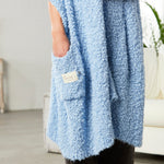 Demdaco Giving Shawl in light blue (27″×70″), buttery‑soft fabric with two pockets—giftable hug, available at Be Charmed.