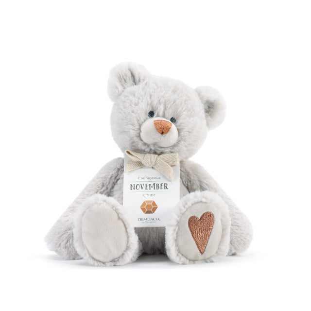 A plush teddy bear with a birthstone theme, featuring a ribbon around its neck that indicates the month of November Available at Be Charmed