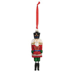 Demdaco blown glass Nutcracker ornament, 7.5″ tall with glitter, resin details & ribbon hanger—traditional holiday heirloom. Available at Be Charmed.