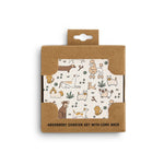 Packaged set of absorbent coasters with cork back featuring illustrations on a white background. Available at Be Charmed