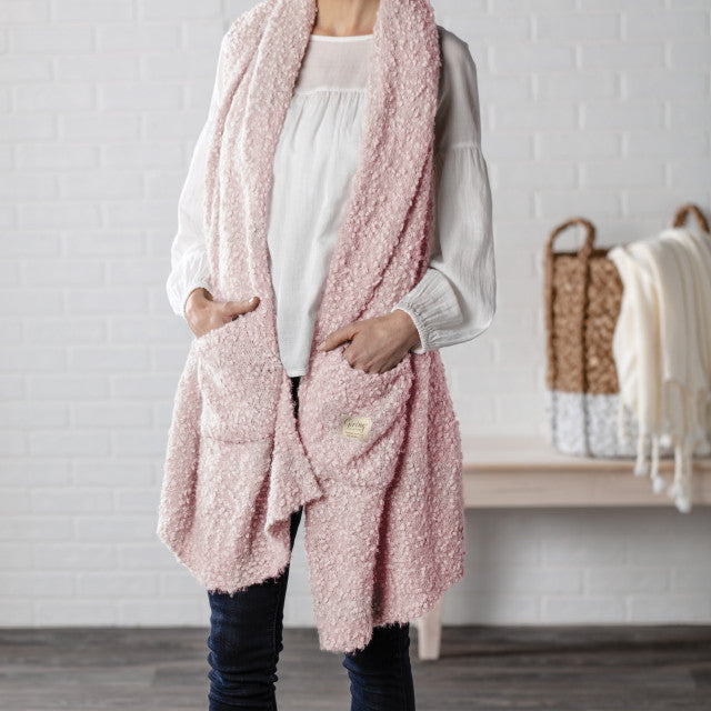 Demdaco Giving Shawl in pink (27″×70″), buttery‑soft fabric with two pockets—giftable hug, available at Be Charmed.
