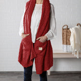 Demdaco Giving Shawl in red (27″×70″), buttery‑soft fabric with two pockets—giftable hug, available at Be Charmed.
