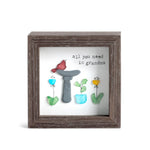 Decorative wall art with a frame, plants, and text on a white background. Available at Be Charmed