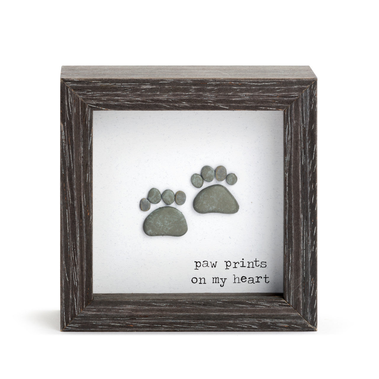 A shadow box with a wooden frame, featuring a silhouette of a pet's paw print on a heart-shaped background, with the text 'Paw Prints on My Heart'. Available at Be Charmed