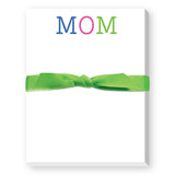 A mini notepad with 'MOM' written on the cover in colorful letters, tied with a green ribbon. Available at Be Charmed
