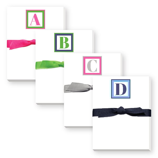 Mini notepads with various initial letters and colored ribbons on top, presented in a square format. Available at Be Charmed