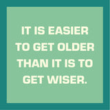 Motivational quote 'It is easier to get older than it is to get wiser.' on a teal coaster. Available at Be Charmed
