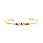 Gold bracelet with multicolored beads on a white background. Available at Be Charmed