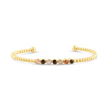 Gold bracelet with multicolored beads on a white background. Available at Be Charmed