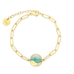 Gold chain bracelet with a turquoise stone on a white background. Available at Be Charmed