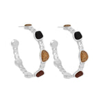 Pair of silver hoop earrings with sand and black stone accents on a white background. Available at Be Charmed