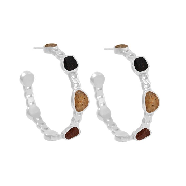 Pair of silver hoop earrings with sand and black stone accents on a white background. Available at Be Charmed