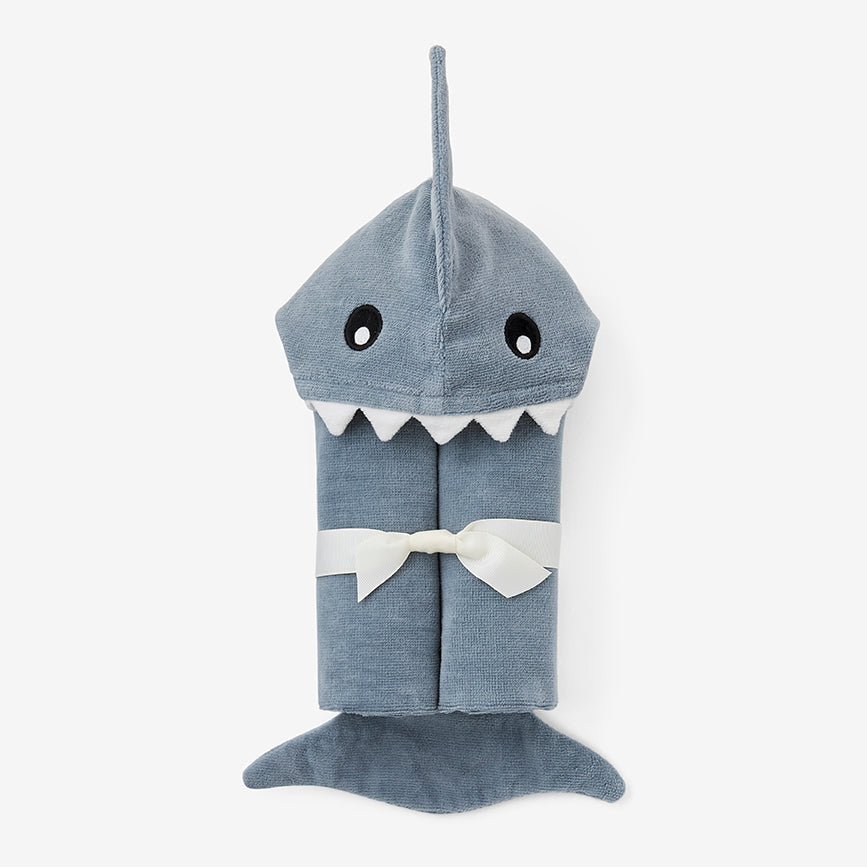 A gray baby bath wrap designed to look like a shark, with a hood featuring an adorable face and tail. Available at Be Charmed