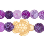 Purple beaded bracelet with a turtle charm on a white background. Available at Be Charmed