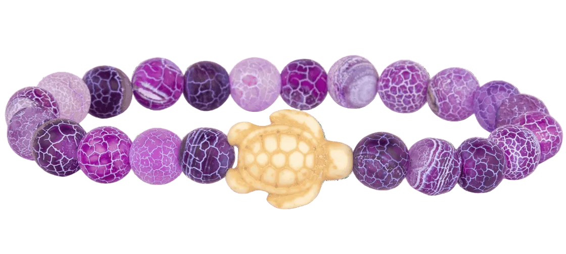 Purple beaded bracelet with a turtle charm on a white background. Available at Be Charmed