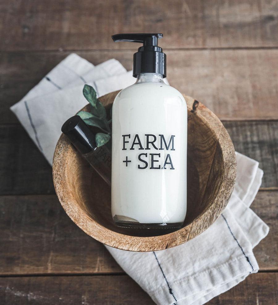 Farm + Sea Beach Girl glass pump body lotion with natural ingredients and coastal scent. Stylish and hydrating. Available at Be Charmed.