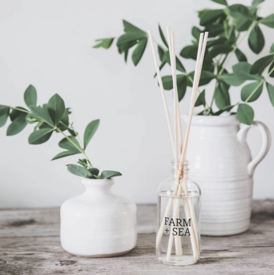 Farm + Sea Cozy Harbor 3oz reed diffuser with warm, inviting scent in a minimalist glass bottle. Long-lasting natural fragrance. Available at Be Charmed.
