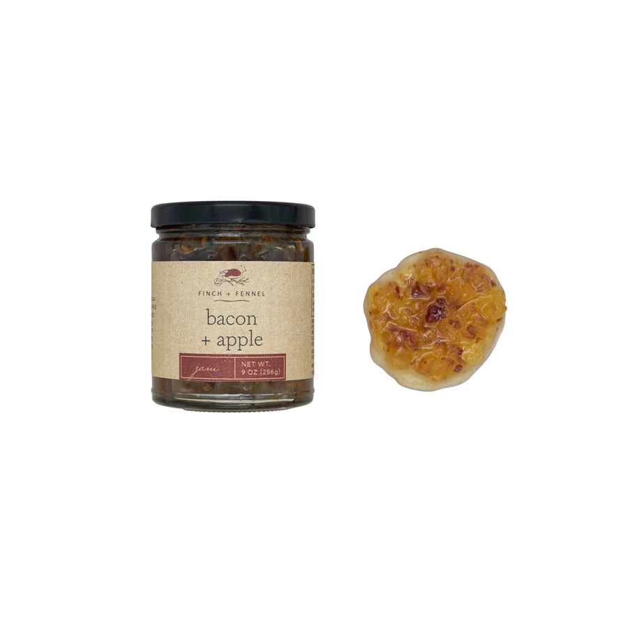 Jar of 'Bacon + Apple' preserve with a piece of preserved fruit on a white background. Available at Be Caharmed